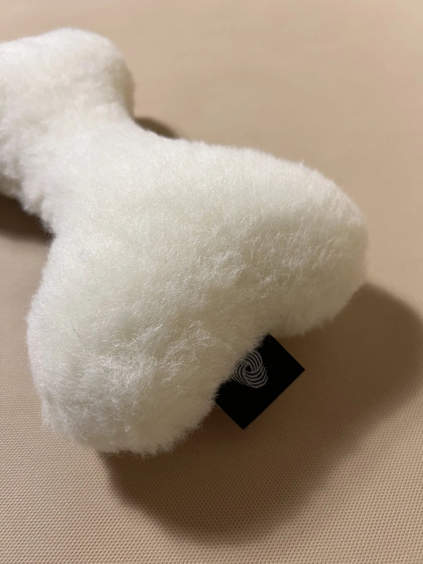 Soft cashmere bone-shaped pet pillow with plush, natural cashmere fabric for comfortable pet rest.