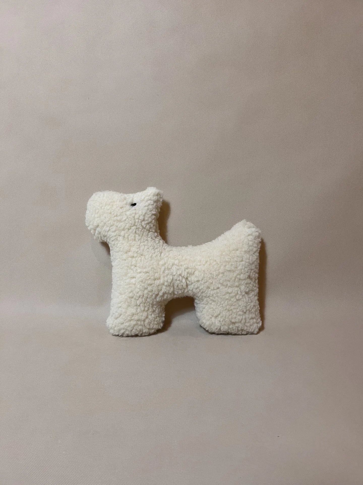 Soft wool plush pet toy featuring a colorful, textural boucle loop material suitable for dogs and cats.