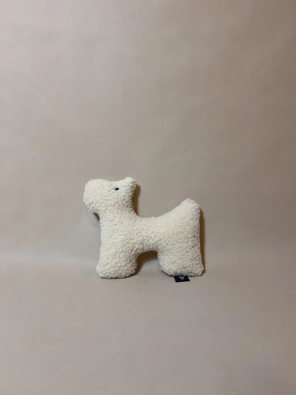 Soft wool plush pet toy featuring a textural boucle loop material for dogs and cats to play and snuggle with.