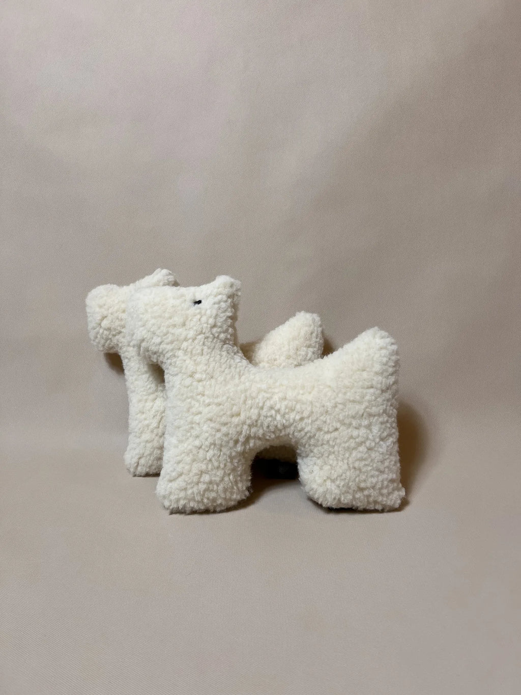 Two soft wool plush pet toys, featuring textural boucle loop material, unique design ideal for cats and dogs.