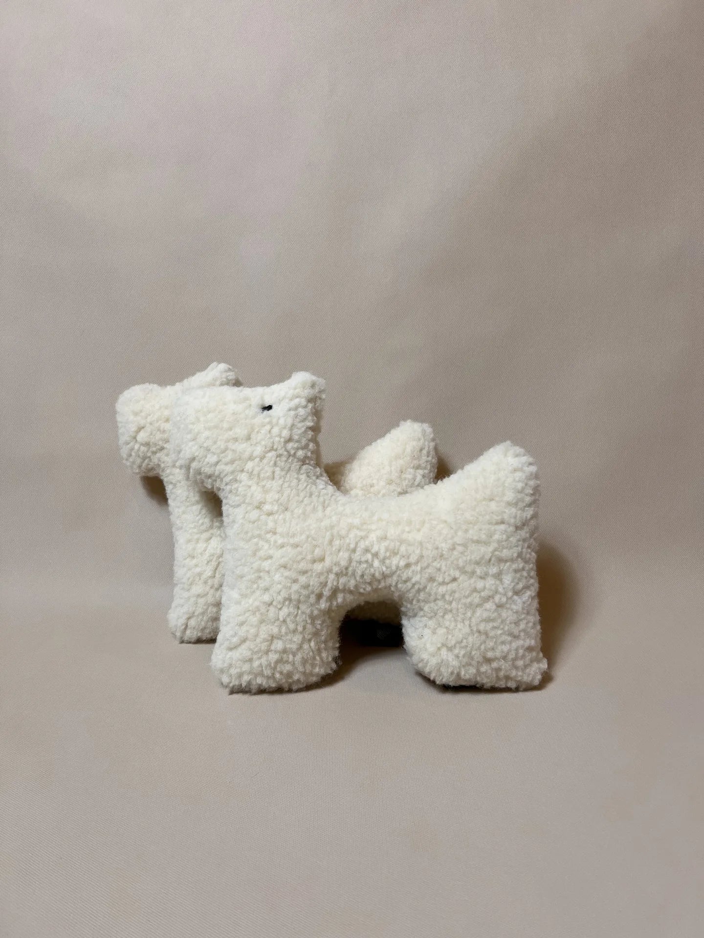 Two soft wool plush pet toys, featuring textural boucle loop material, unique design ideal for cats and dogs.
