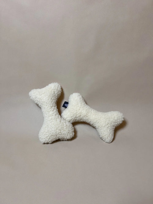 Soft wool bone-shaped pet pillow with boucle loop texture.