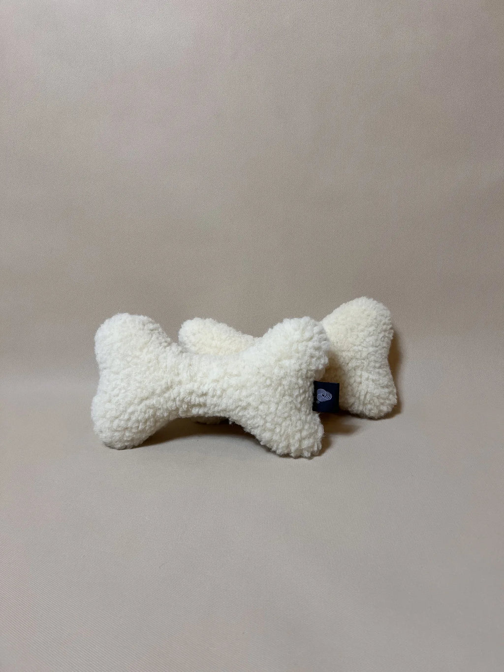 Soft wool bone pet pillow featuring boucle loop texture, with plush design perfect for comfort and rest for small pets.