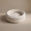 Soft wool and cashmere pet bed by featuring a plush design for comfort in a neutral color.