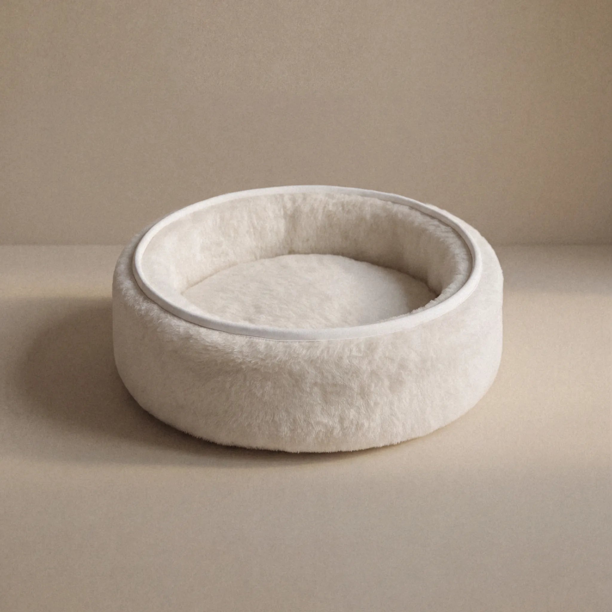 Soft wool and cashmere pet bed by featuring a plush design for comfort in a neutral color.