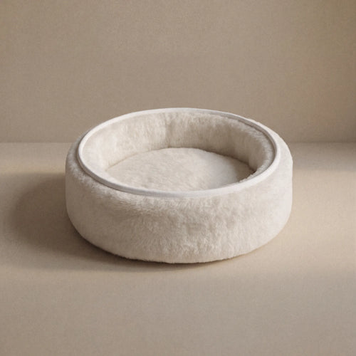 Soft wool and cashmere pet bed by featuring a plush design for comfort in a neutral color.