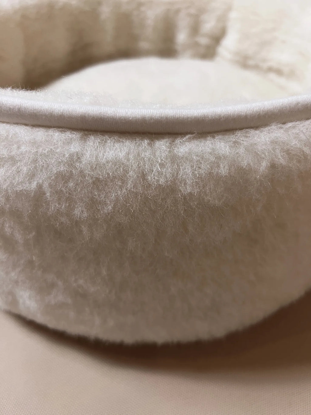 Soft wool and cashmere pet bed with plush, textural fabric and cushioned design for all pets.