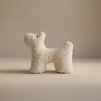 A small wool plush pet toy featuring a bouclé loop textured material, standing on a neutral beige background.