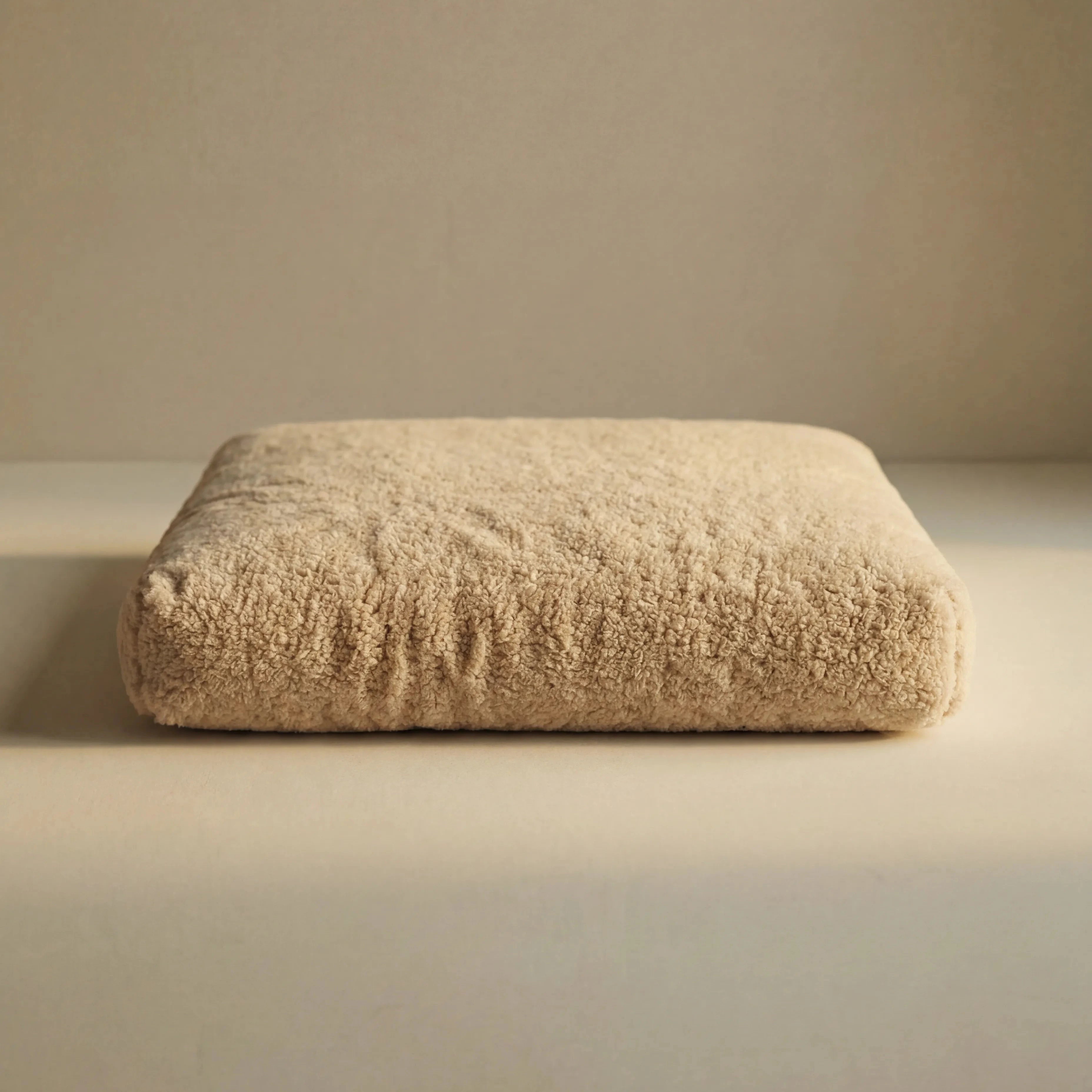 Beige 'Wool Lounge Boucle Pet Bed' on a beige background.